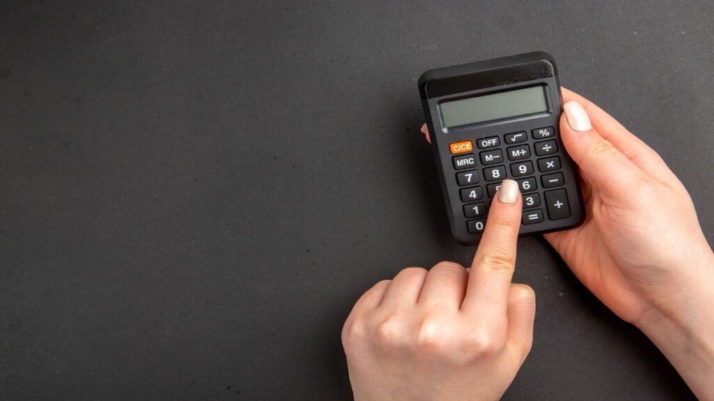 imagem de mão feminina fazendo cálculo em calculadora
